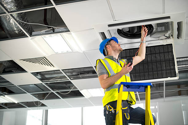 técnico instalando cassette de aire acondicionado industrial en techo de oficina Barcelona