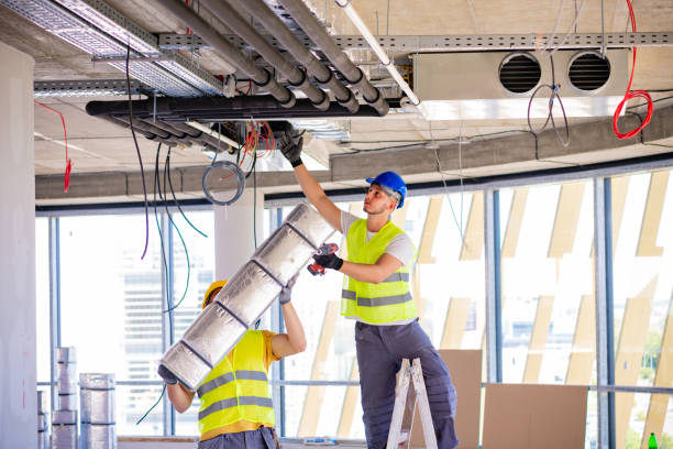 técnicos instalando conductos de aire acondicionado industrial en oficina de Barcelona